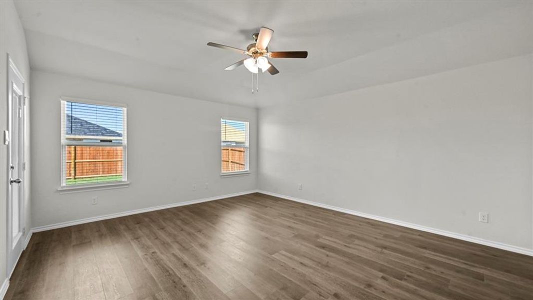 Empty room featuring dark wood-style flooring and a ceiling fan