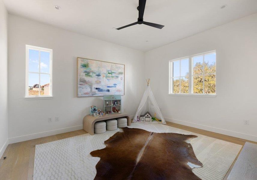 Recreation room featuring light wood-style flooring and a ceiling fan