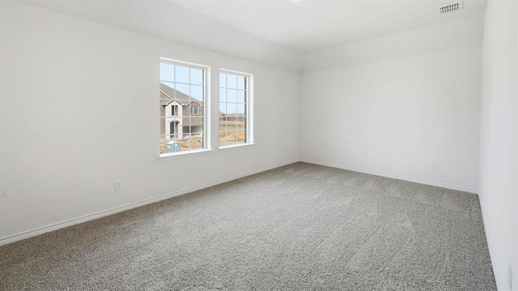 Empty room with light colored carpet and baseboards