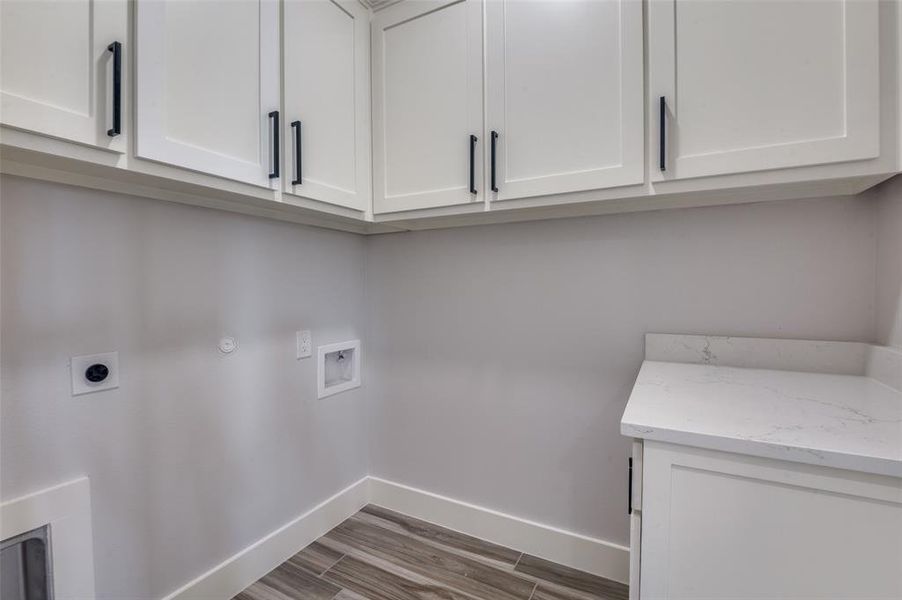 Washroom featuring light hardwood / wood-style flooring, gas dryer hookup, cabinets, hookup for an electric dryer, and hookup for a washing machine