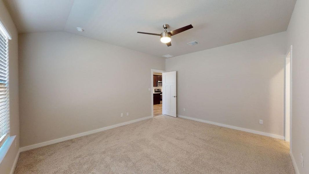 A spacious, naturally illuminated room features plush carpeting and a ceiling fan, offering a comfortable retreat. A spacious, naturally illuminated room features plush carpeting and a ceiling fan, offering a comfortable retreat.