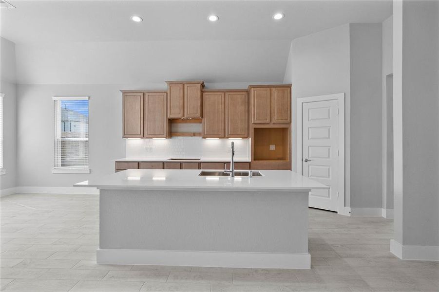 This kitchen is by far any chef’s dream! This spacious kitchen features high ceilings, stained wood cabinets, quartz countertops, SS appliances, modern tile backsplash, recessed lighting, quartz kitchen island with space for breakfast bar, and a walk-in pantry all overlooking your huge family room.