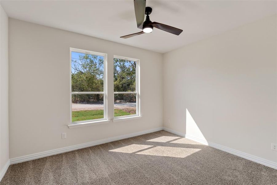 Empty room featuring ceiling fan and carpet floors