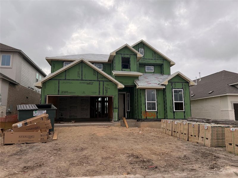 A newly framed residence, sheathed in green weather-resistant barrier, awaits its finishing touches. A newly framed residence, sheathed in green weather-resistant barrier, awaits its finishing touches.