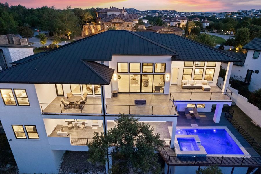 Outdoors, multiple covered terraces invite year-round enjoyment with a resort-style pool and spa, summer kitchen, firepit, and sweeping canyon views.