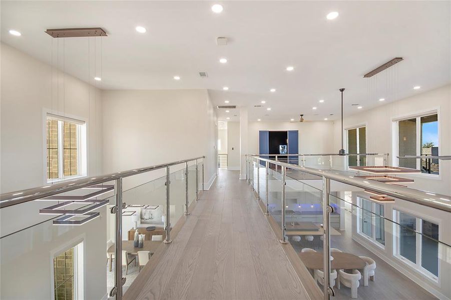 Hall featuring light wood-type flooring, recessed lighting, and an upstairs landing Hall featuring light wood-type flooring, recessed lighting, and an upstairs landing