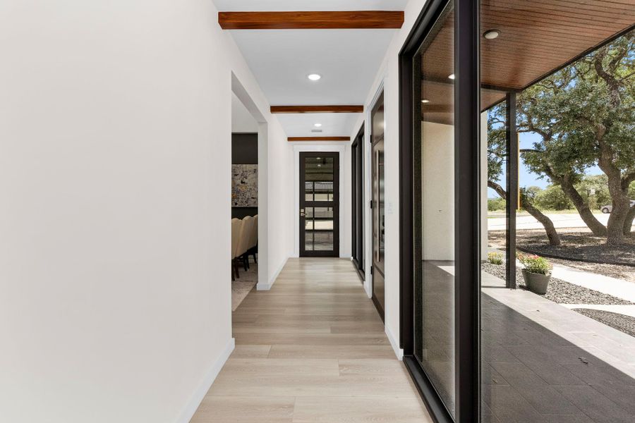 Hallway featuring expansive windows, light wood-style floors, and recessed lighting