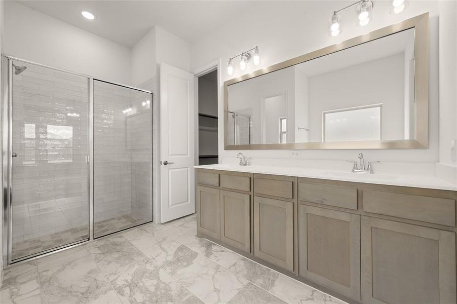 Full bath featuring marble finish flooring, double vanity, a shower stall, and recessed lighting