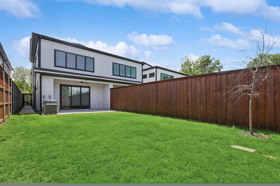 Back of property with a patio area, a lawn, and central AC unit