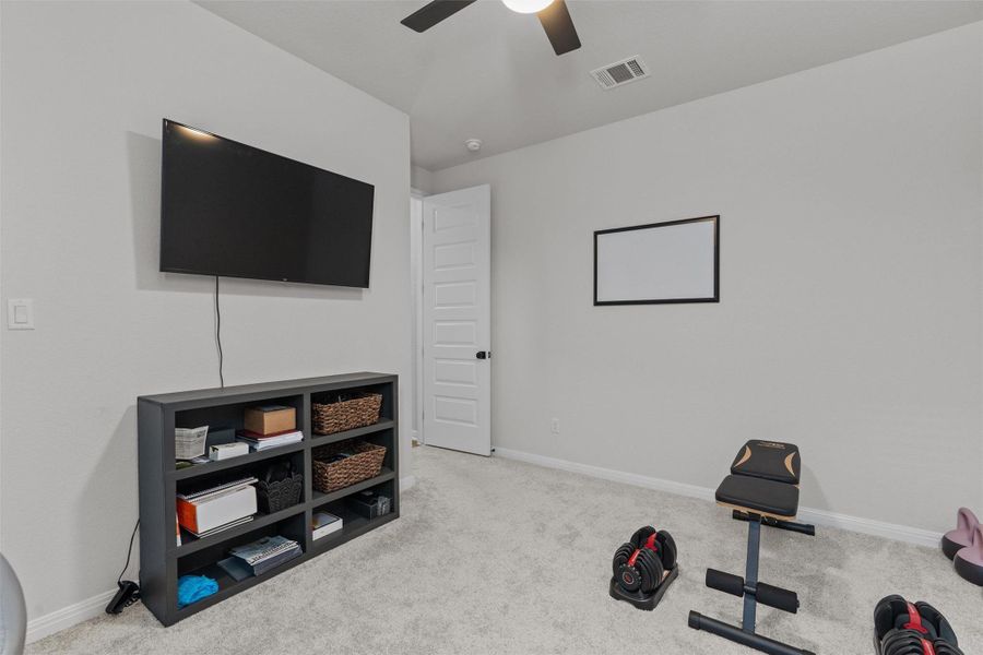 Workout room featuring light colored carpet and ceiling fan