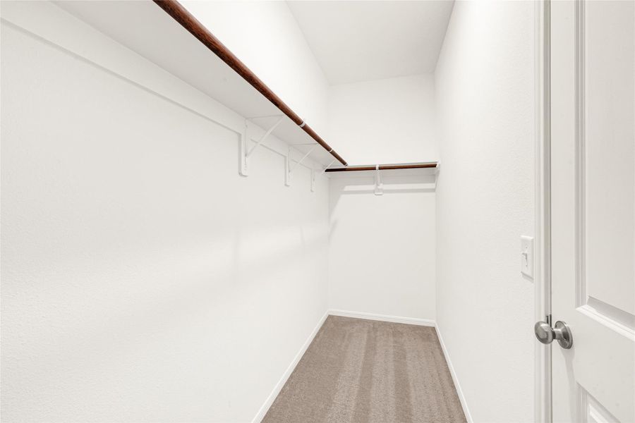 Functional walk-in closet space featuring built-in shelving and hanging rods.