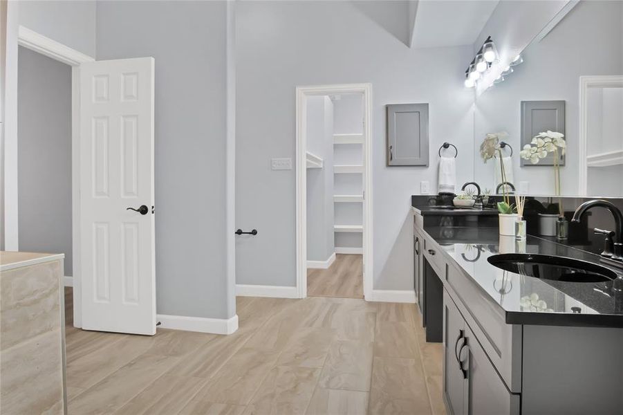 Primary bathroom with granite vanities, and a medicine cabinet.