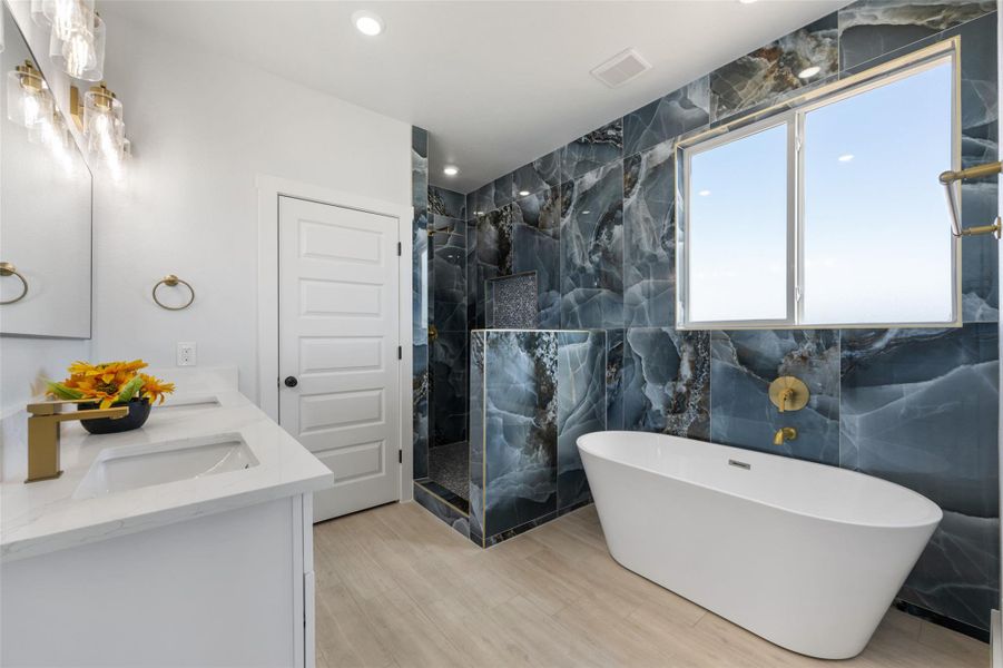 Bathroom with a soaking tub, a marble finish shower, double vanity, tile walls, and recessed lighting