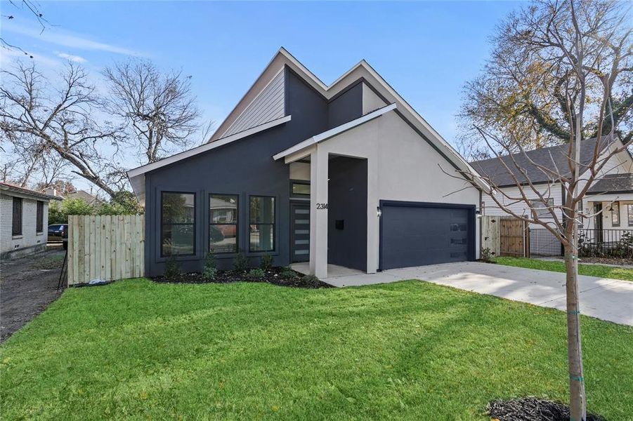 View of front of home with a front yard and a garage