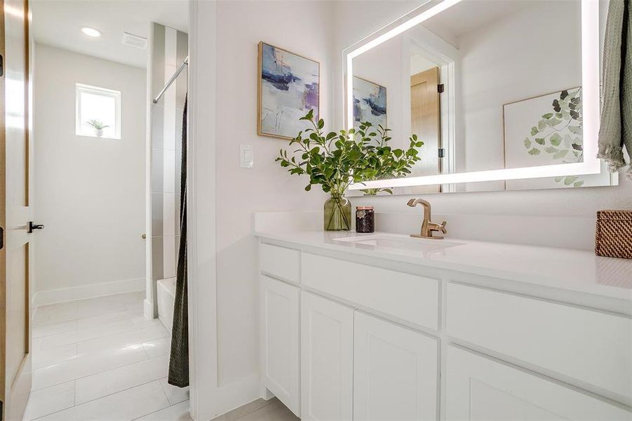 Bathroom featuring light tile patterned floors, vanity, and shower / bath combo