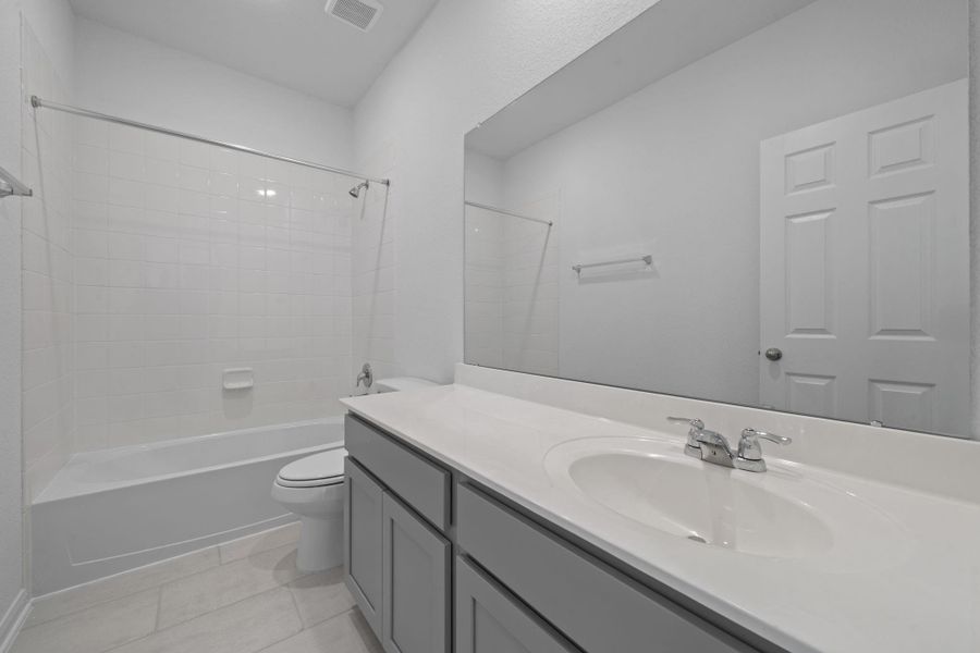 The secondary bath features tile flooring, white cabinetry and light countertops and a shower/tub combo. Perfect for accommodating any visiting family and friends. The secondary bath features tile flooring, white cabinetry and light countertops and a shower/tub combo. Perfect for accommodating any visiting family and friends.