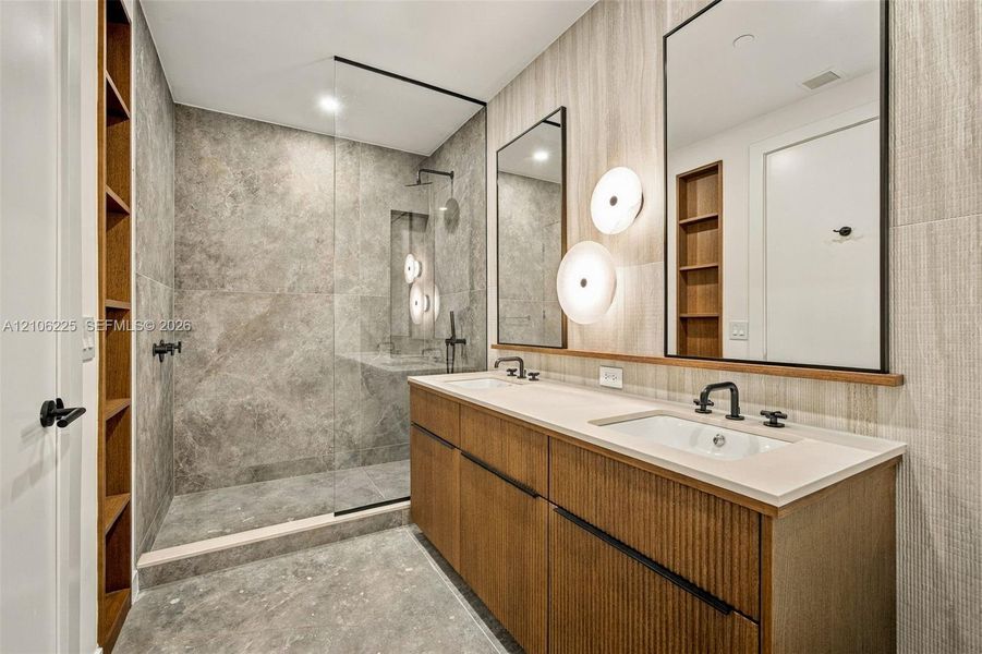 Custom vanity with a solid-surface countertop, integrated dual sinks, and matte black widespread faucets Custom vanity with a solid-surface countertop, integrated dual sinks, and matte black widespread faucets