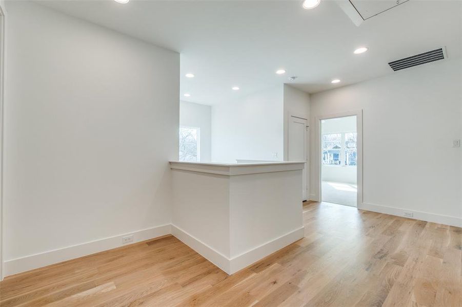 Unfurnished room featuring a healthy amount of sunlight and light hardwood / wood-style floors