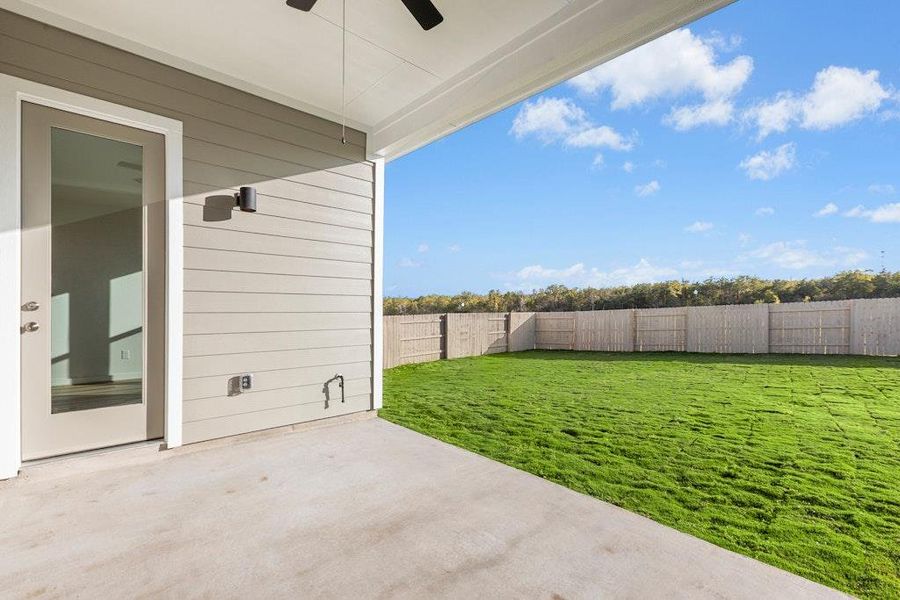 Fenced backyard with a patio and ceiling fan