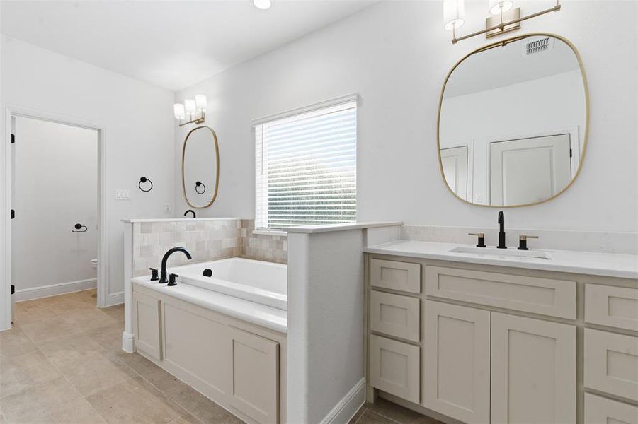 Bathroom with a bath, light tile patterned floors, and vanity Bathroom with a bath, light tile patterned floors, and vanity