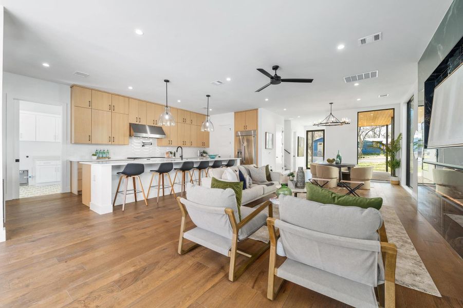 Living room with ceiling fan with notable chandelier, recessed lighting, light wood-style floors, and visible vents