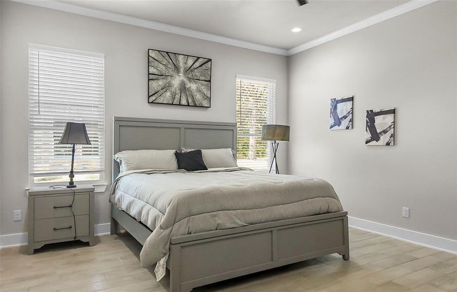 Bedroom with ornamental molding, light wood-style flooring, and recessed lighting