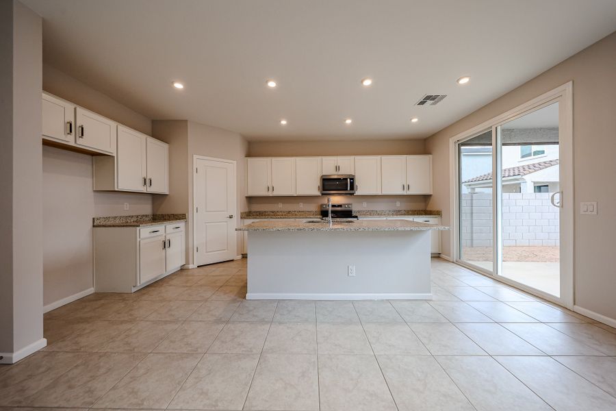 A kitchen with white cabinets.