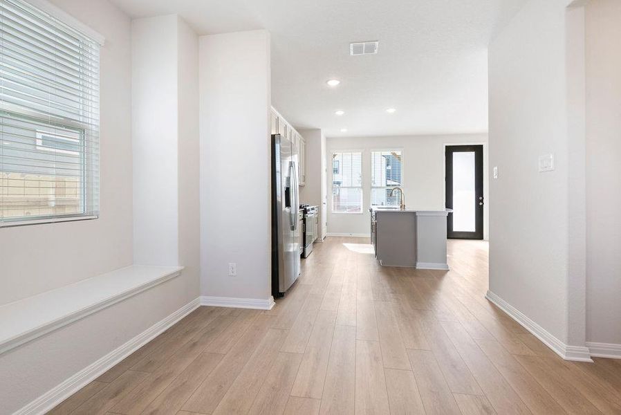 Kitchen with a kitchen island with sink, stainless steel appliances, light wood-style flooring, and recessed lighting