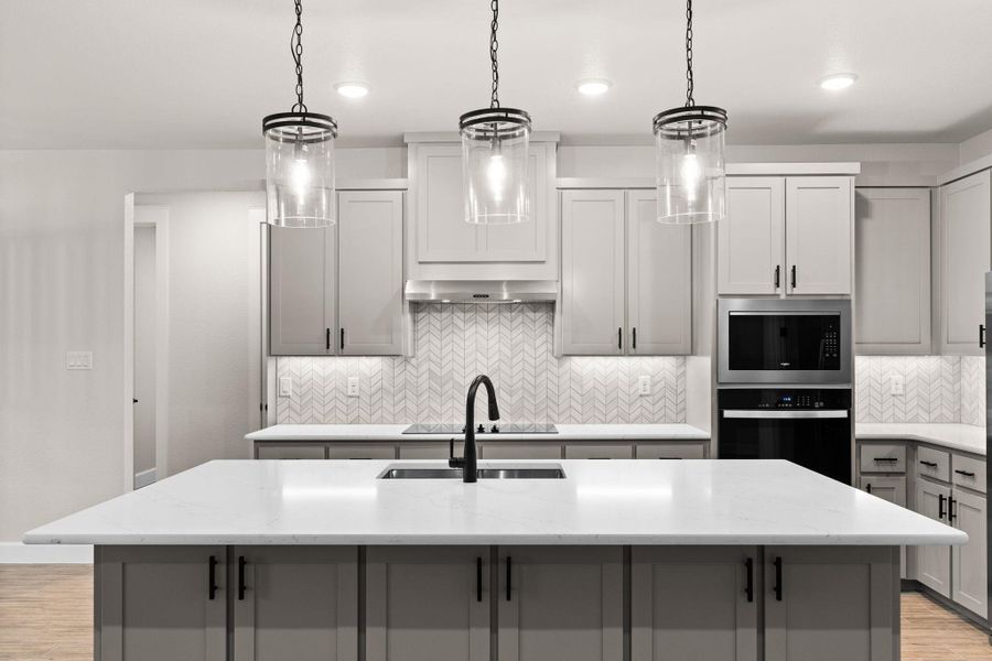 Kitchen featuring light wood-type flooring, gray cabinetry, tasteful backsplash, pendant lighting, and recessed lighting Kitchen featuring light wood-type flooring, gray cabinetry, tasteful backsplash, pendant lighting, and recessed lighting