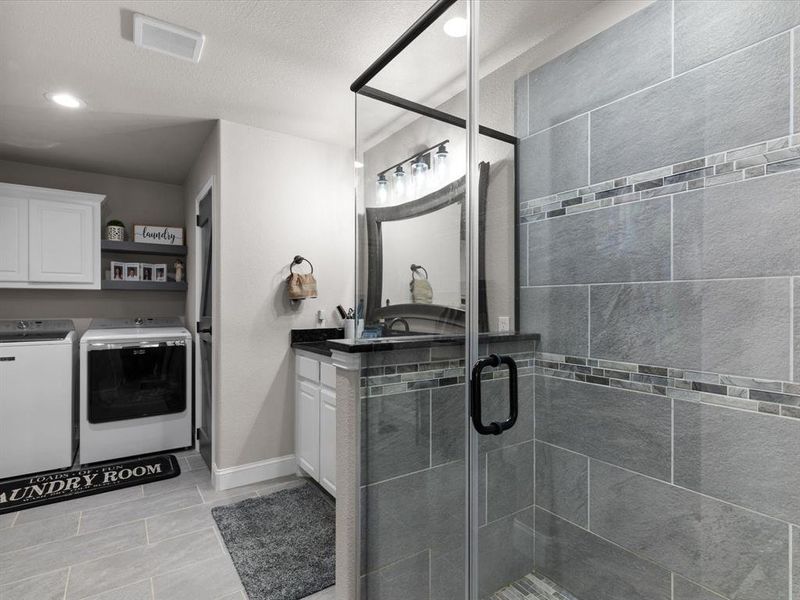 Full bath featuring visible vents, a shower stall, baseboards, independent washer and dryer, and vanity