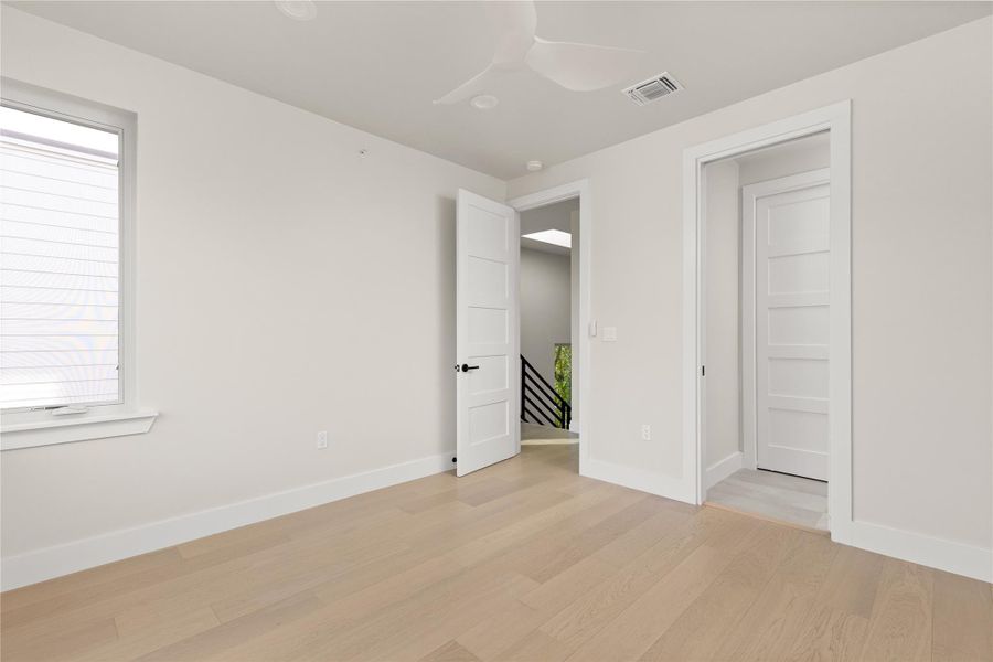 Smooth wood floors and crisp white trim enhance this serene upper-level room.