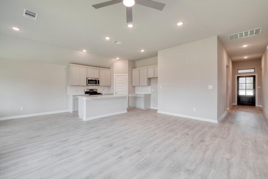 An open floorplan seamlessly connects the kitchen and living areas, bathed in natural light. An open floorplan seamlessly connects the kitchen and living areas, bathed in natural light.