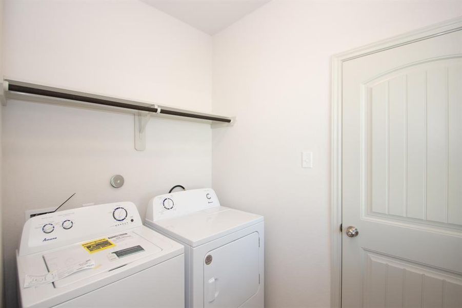 Simplify your daily routines with this convenient in-house laundry room! Equipped with washer and dryer hookups, it features an overhead shelf for easy storage of detergents and laundry essentials. The private, enclosed space makes laundry a breeze, while the clean and modern design complements the rest of the home. Functional and accessible, this laundry room is a practical addition to your new home.