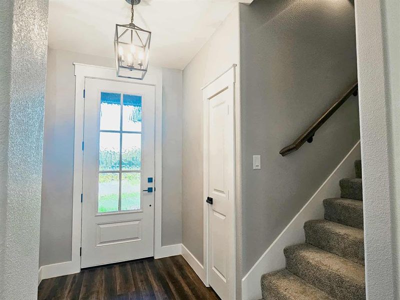 Front door entrance with hall way to upstairs and coat closet.