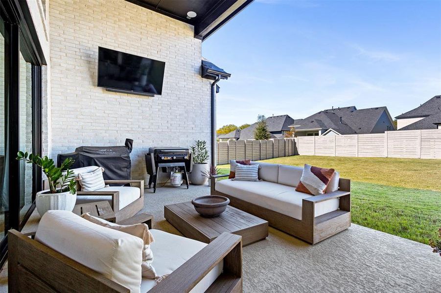 Fenced backyard with a patio, grilling area, and an outdoor hangout area Fenced backyard with a patio, grilling area, and an outdoor hangout area