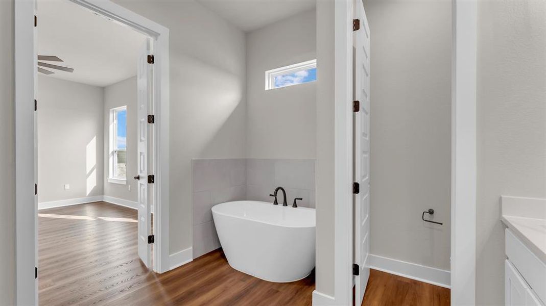 Rich wood floors contrast beautifully with light walls and a deep freestanding soaking tub. Rich wood floors contrast beautifully with light walls and a deep freestanding soaking tub.