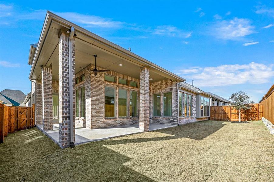 Rear view of house featuring a patio area and a lawn