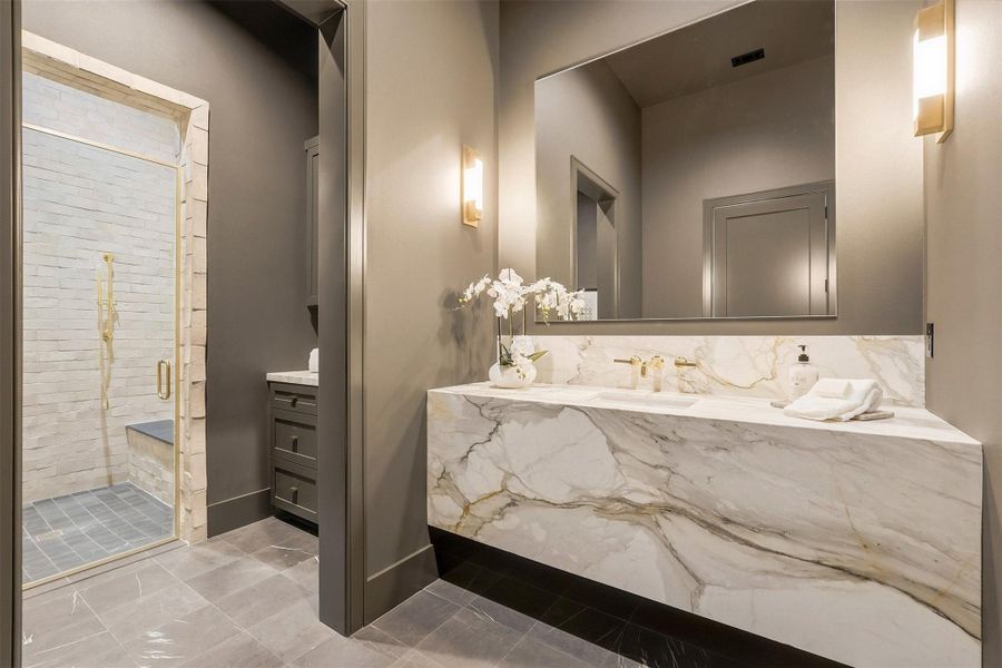 Just steps from the first-floor game room, a beautifully appointed bathroom features a luxurious walk-in shower, combining convenience with underrated elegance. Just steps from the first-floor game room, a beautifully appointed bathroom features a luxurious walk-in shower, combining convenience with underrated elegance.