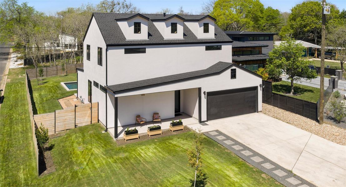 View of front of property with stucco siding, driveway, an attached garage, and roof with shingles