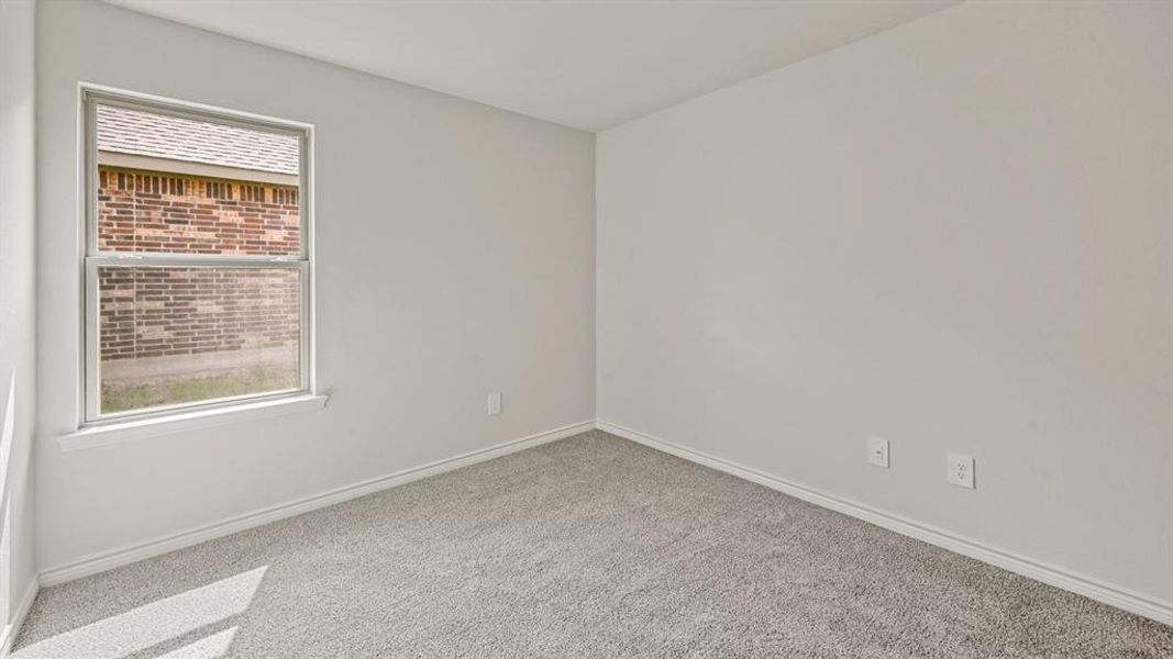 Room featuring light gray carpeting, white baseboards, and neutral wall tones Room featuring light gray carpeting, white baseboards, and neutral wall tones