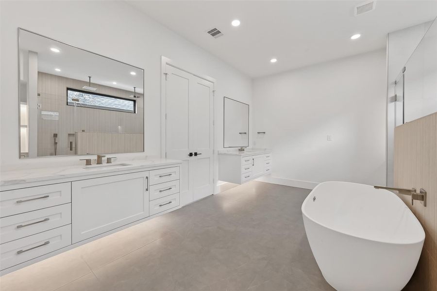 Spa-like primary bath with floating dual vanities and freestanding tub.