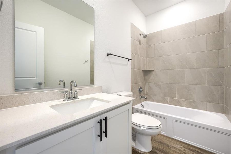 Full bath featuring shower / bathtub combination, vanity, and dark wood-style flooring Full bath featuring shower / bathtub combination, vanity, and dark wood-style flooring