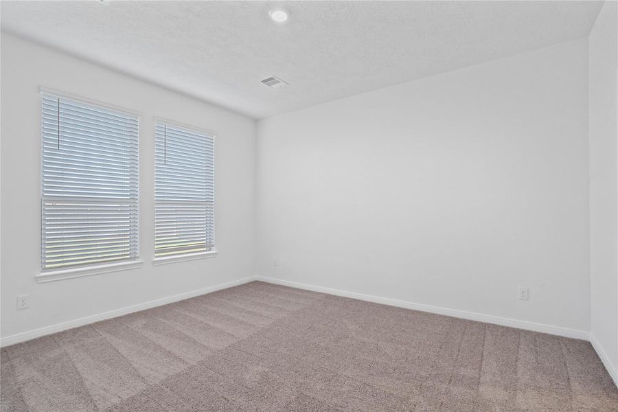 Relax and recharge in this stunning primary suite! Enjoy the comfort of plush carpeting, neutral-toned walls, high ceilings, recessed lighting, and large windows with privacy blinds that fil the room with natural light.