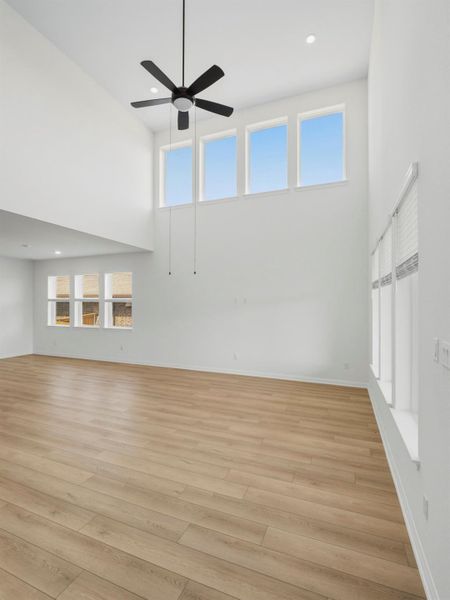 A grand living area showcases soaring ceilings and plentiful natural light through a series of tall windows. A grand living area showcases soaring ceilings and plentiful natural light through a series of tall windows.