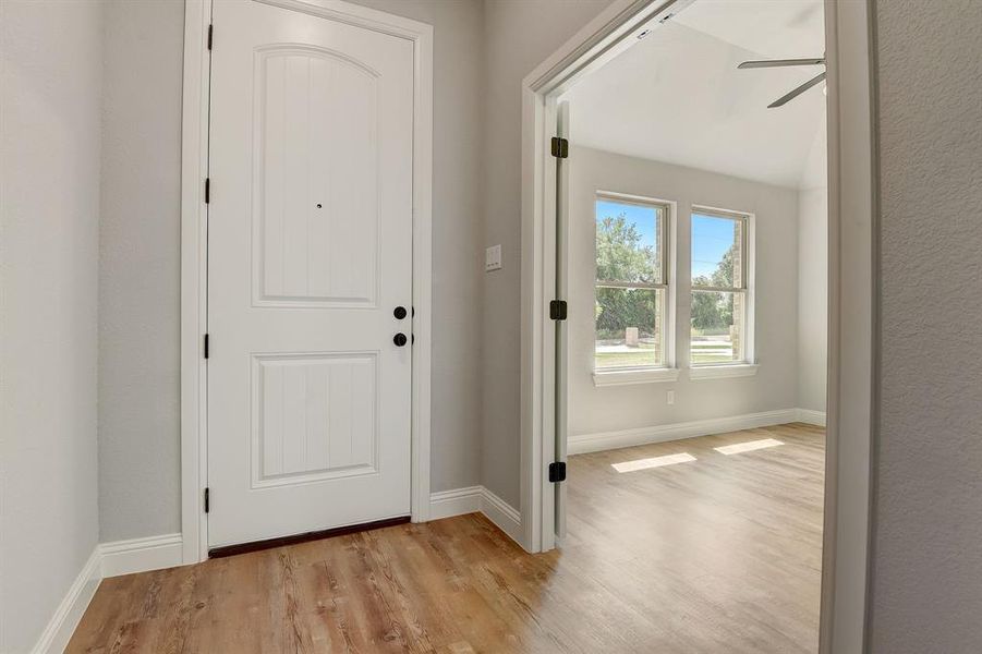 Foyer entrance with ceiling fan and light hardwood / wood-style floors