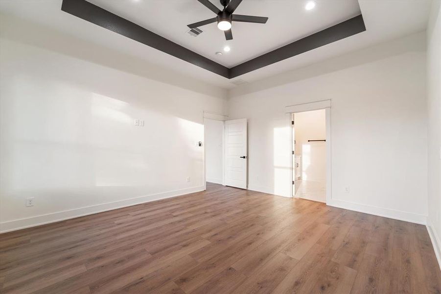 The primary bedroom has a stylish tray ceiling with recessed lighting and a ceiling fan. Natural light floods in through two windows and has your cable/TV hookups ready to go!