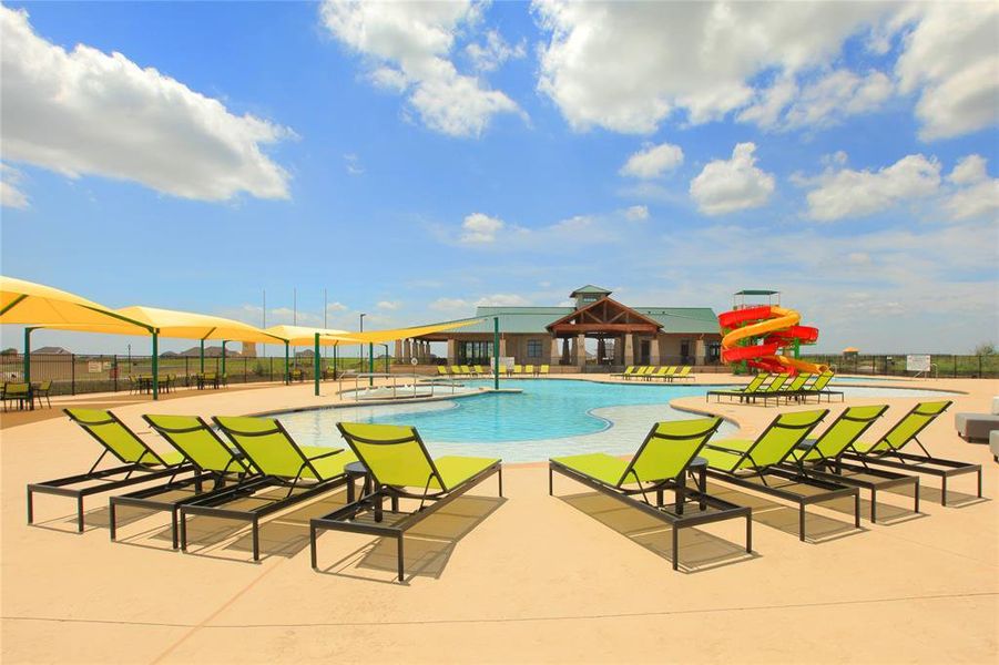 Expansive community pool area featuring a resort-style swimming pool, a vibrant waterslide, and multiple shaded lounge areas Expansive community pool area featuring a resort-style swimming pool, a vibrant waterslide, and multiple shaded lounge areas