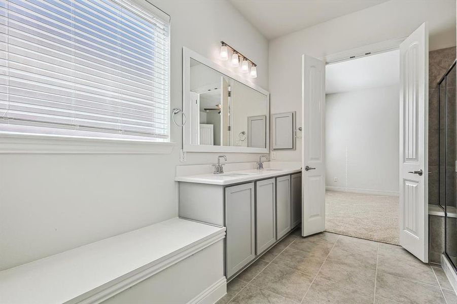 Bathroom with tile patterned flooring, a shower with shower door, and vanity