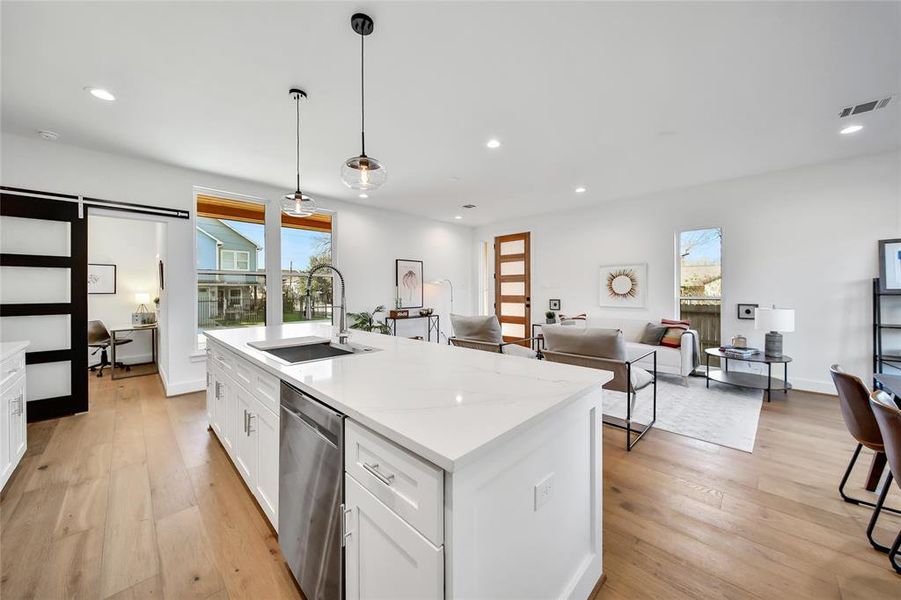 This photo was taken in another staged property with the same finishes and layout. View of the open living and kitchen spaces from the pantry.