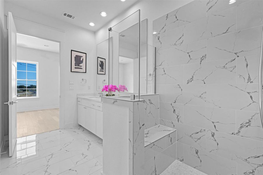 Bathroom with light marble finish floors, vanity, a marble finish shower, and recessed lighting